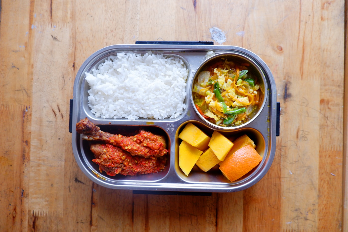 Chicken and rice lunch box with vegetables and fruit